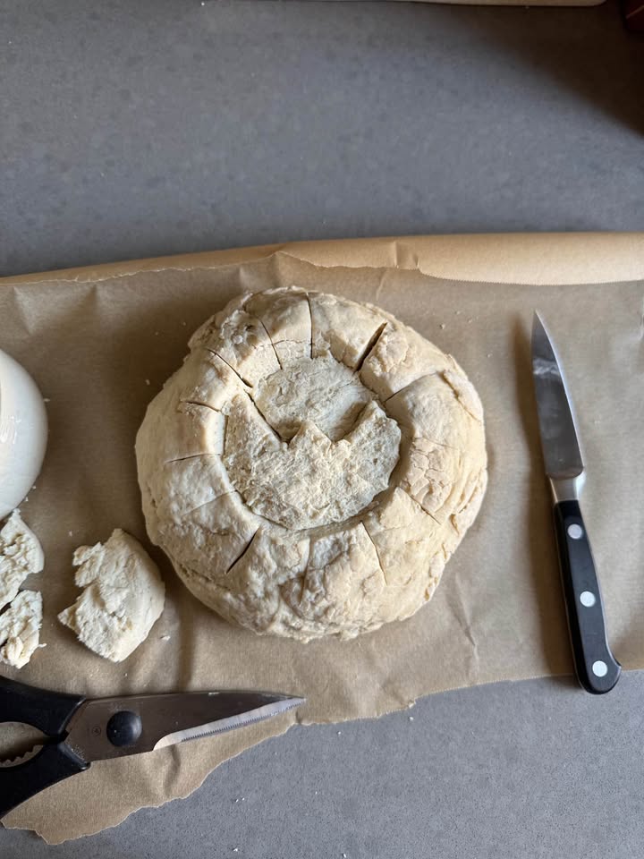 A sourdough loaf scored with a smiley face design