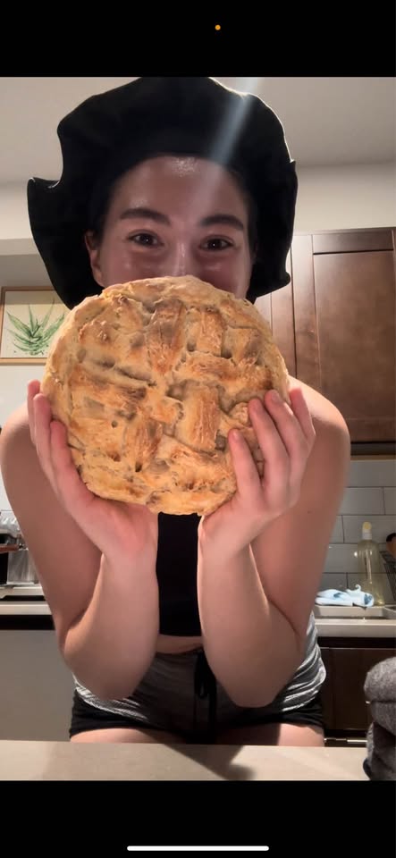 Persephone holding a large homemade sourdough loaf